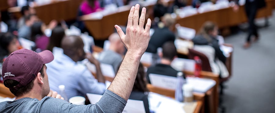 Student raises his hand in an HBS classroom