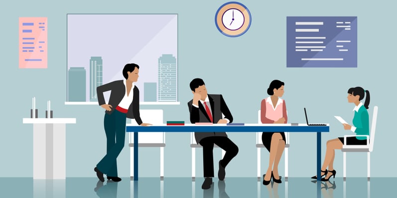 Office meeting room with 3 people seated at a table and one standing